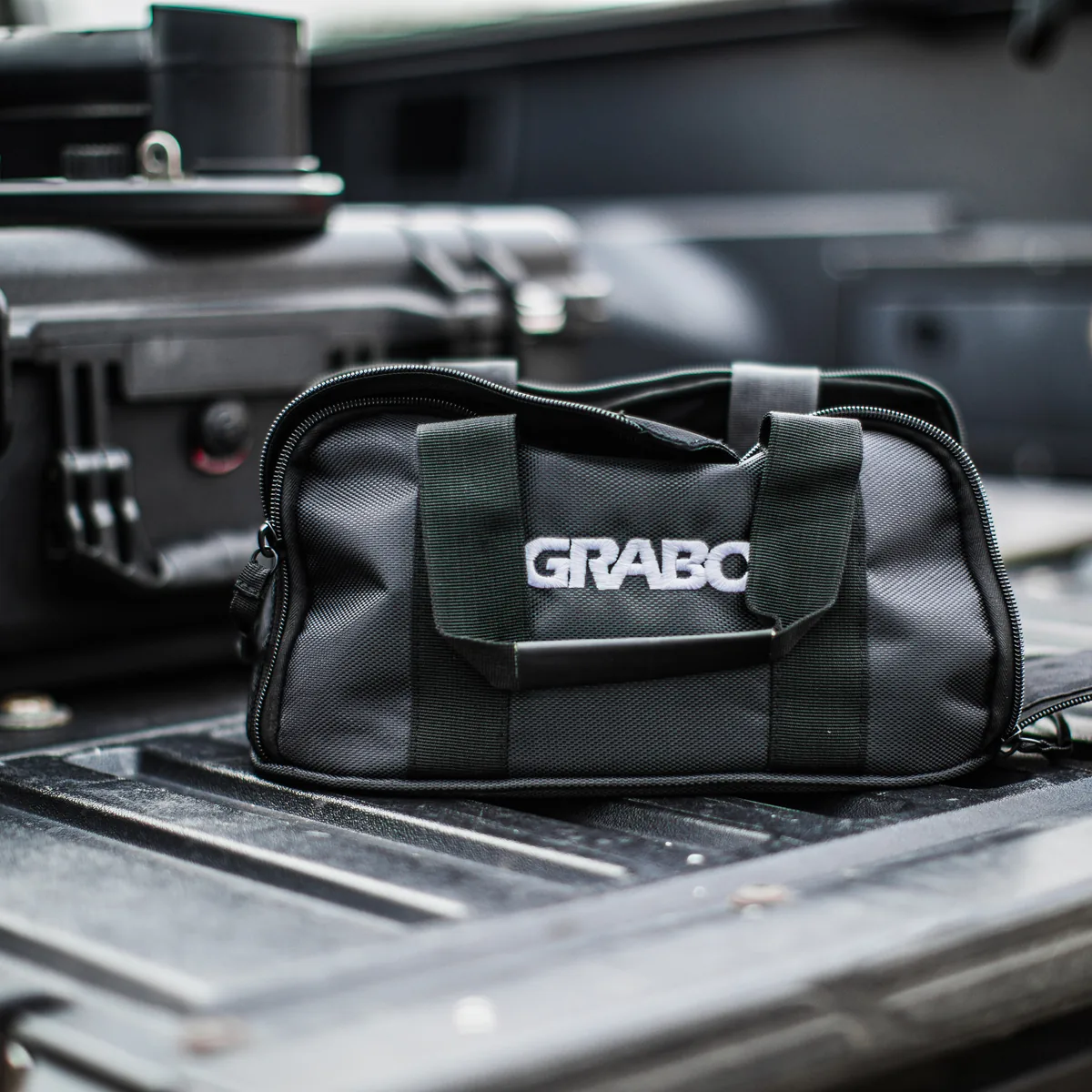 GRABO® 包放在卡车车厢上，旁边是工具箱